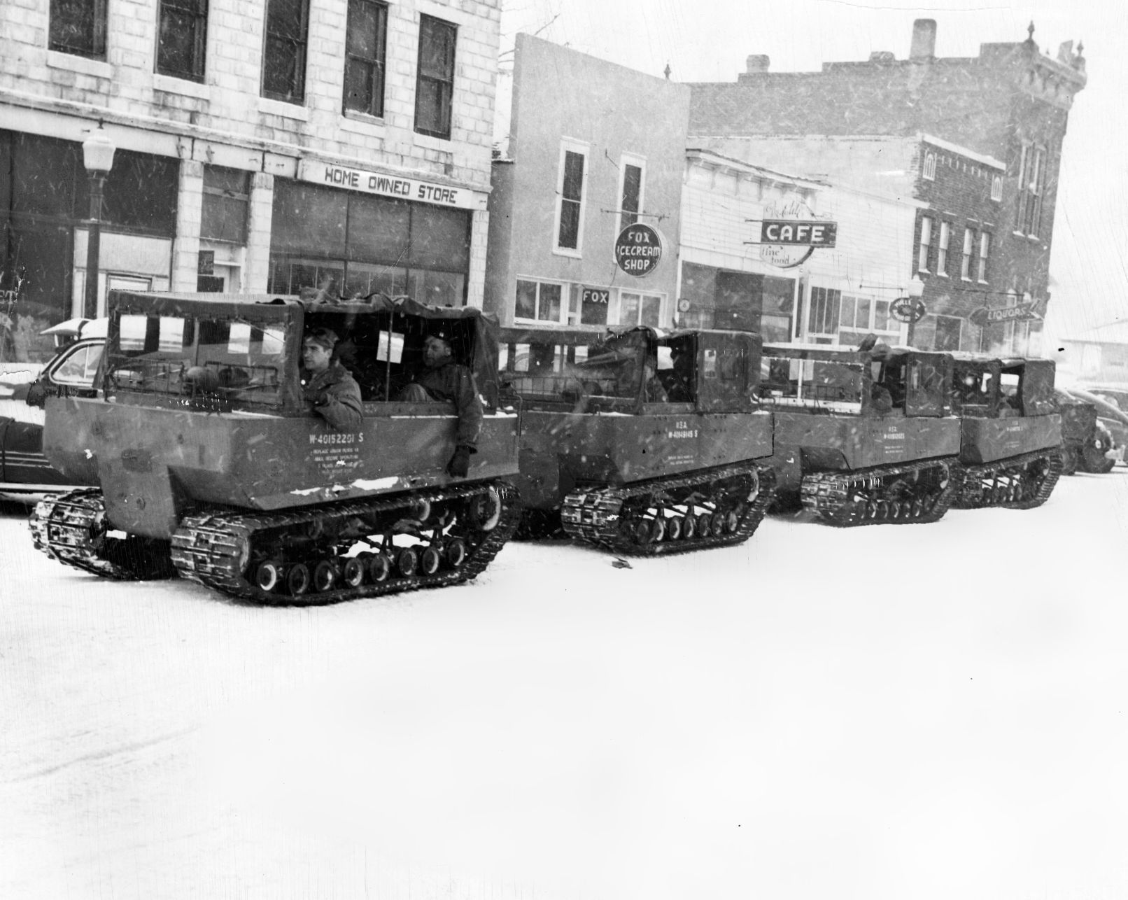 A group of weasels, with Fifth Army men driving, roll down the main street of O'Neill. The servicemen and their caterpillar treaded vehicles took food and supplies to hundreds of isolated families. Published Feb. 4, 1949.